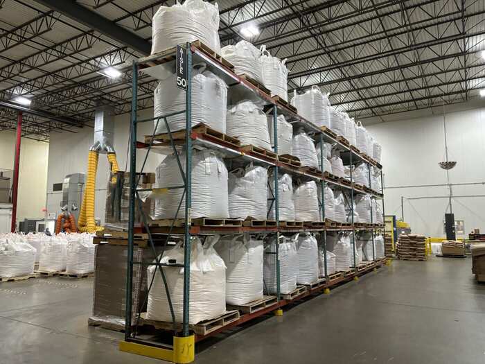 Interior of a high-bay warehouse with racked storage and marked traffic lanes